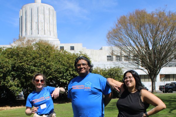 Three people stand in front of the Oregon State Capitol Building