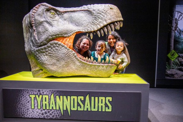 A family poses for a photo in the head of a tyrannosaurus