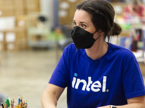 A woman in a blue Intel shirt wearing a black mask