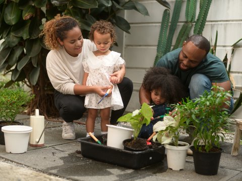 A young family planting outside their home.