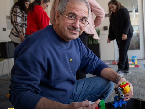 a man kneels smiling